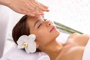 woman with flower in hair receiving reiki healing